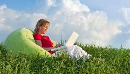 woman sitting in field on beanbag chair