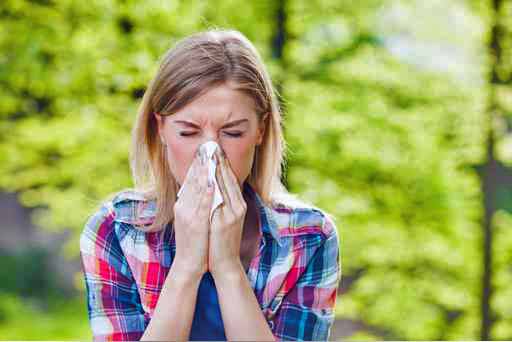 woman sneezing with allergies